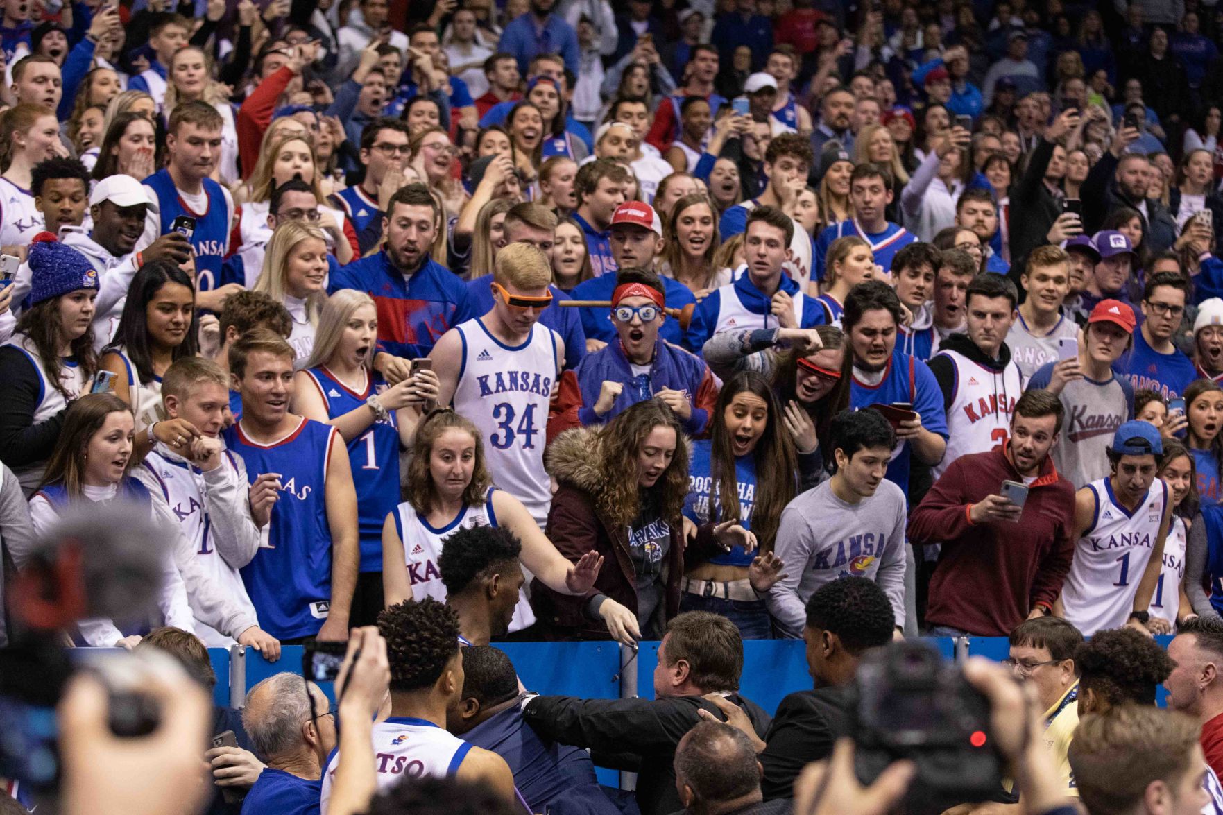 The crowd expresses shocked emotions as Bill Self separates his players during an altercation.